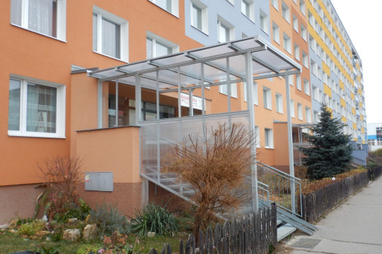 Realizace zastřešení a zasklení bočních stěn vstupního schodiště do panelového domu