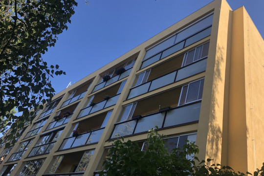 Realizace rámového posuvného zasklení bytového domu s instalací venkovních rolet s větracími lamelami