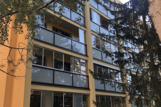Realizace rámového posuvného zasklení bytového domu s instalací venkovních rolet s větracími lamelami