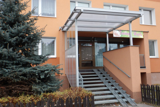 Realizace zastřešení a zasklení bočních stěn vstupního schodiště do panelového domu