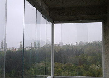 Zasklení a zastřešení rohového balkónu v bytovém domě