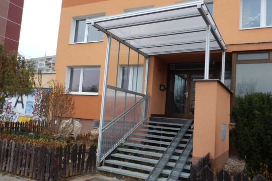 Realizace zastřešení a zasklení bočních stěn vstupního schodiště do panelového domu