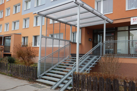 Realizace zastřešení a zasklení bočních stěn vstupního schodiště do panelového domu