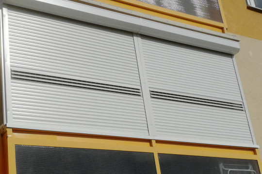 Detailní pohled na zataženou venkovní roletu s větracími lamelami