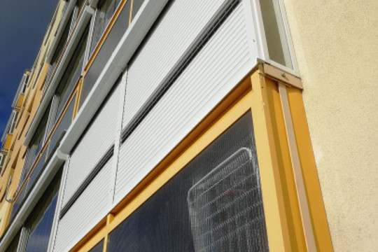 Zasklení balkónů a zastínění venkovními roletami s větracími lamelami v bytovém domě