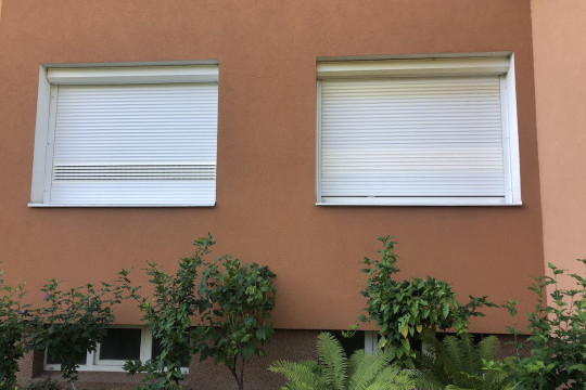 Detailní pohled na stažené rolety s otevřenými větracími lamelami